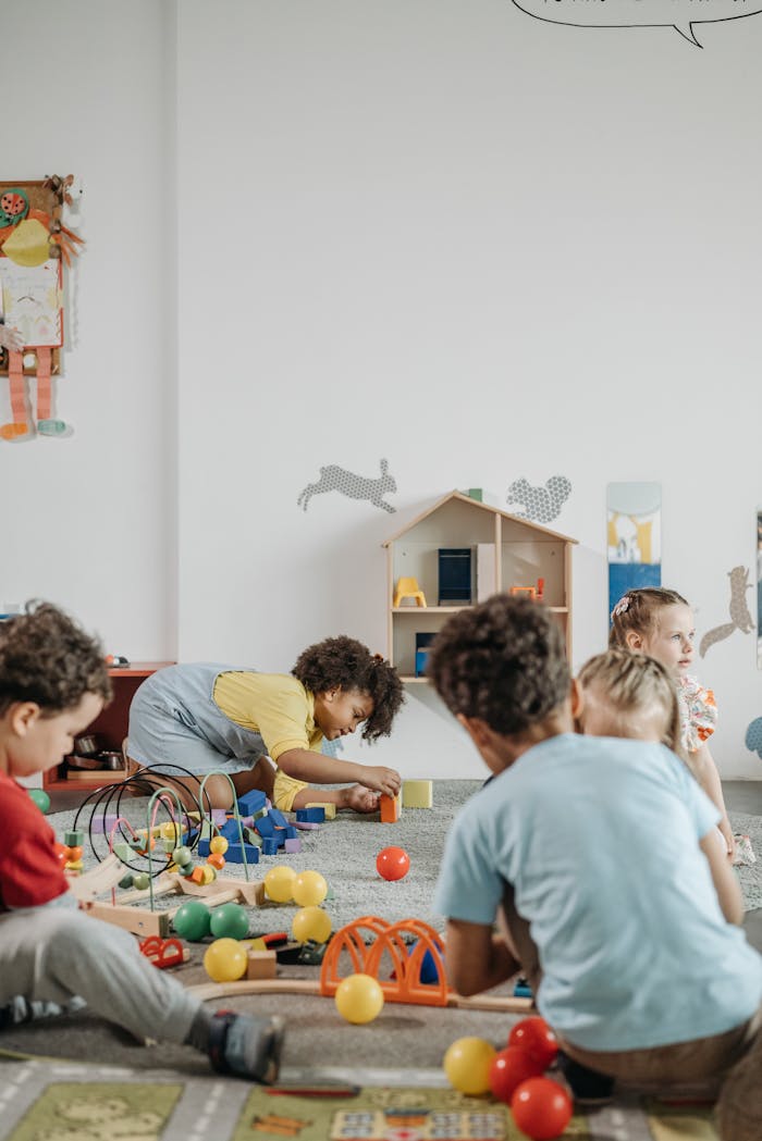Home A lively group of children playing inside a colorful kindergarten classroom.